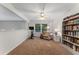 Bright bonus room features plush carpet, a ceiling fan, workout bike, and a cozy sitting area with bookcase at 1055 Beacon Hill Xing, Alpharetta, GA 30005