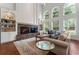 Bright and spacious living room with a stone fireplace, large windows, and hardwood floors at 1055 Beacon Hill Xing, Alpharetta, GA 30005