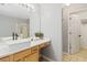 Modern bathroom with a vessel sink, a light wood vanity, and access to the walk-in closet at 2457 Birkhall Way # 2457, Lawrenceville, GA 30043