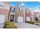 Charming townhome exterior featuring a well-maintained lawn and attached one-car garage at 2457 Birkhall Way # 2457, Lawrenceville, GA 30043