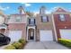 Charming townhome with brick facade, complemented by a one-car garage and manicured landscaping at 2457 Birkhall Way # 2457, Lawrenceville, GA 30043