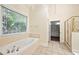 A soaking tub sits beside a large window bringing natural light into the bright and elegant bathroom at 3753 Honey Pot Ne Way, Marietta, GA 30066
