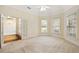 Well-lit bedroom featuring two windows, carpet, and French doors to a bathroom at 3753 Honey Pot Ne Way, Marietta, GA 30066