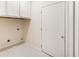 A clean and functional laundry room with white cabinets and tile flooring at 3753 Honey Pot Ne Way, Marietta, GA 30066