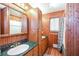 Vintage-style bathroom with wood-paneled walls, a sink, built-in storage, and a shower-tub combination offering functionality at 3985 Loch Highland Ne Pass, Roswell, GA 30075