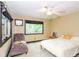 Bright bedroom with a ceiling fan, windows for natural light, and a sitting area with a comfortable chaise lounge at 3985 Loch Highland Ne Pass, Roswell, GA 30075