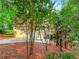 View of house exterior with a driveway surrounded by trees and other landscaping at 3985 Loch Highland Ne Pass, Roswell, GA 30075