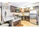 Compact kitchen features stainless steel appliances, granite countertops, dark wood cabinets, and counter seating for casual dining at 3985 Loch Highland Ne Pass, Roswell, GA 30075
