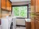 Functional laundry room with modern washer and dryer, cabinetry, and a view of the outdoors at 3985 Loch Highland Ne Pass, Roswell, GA 30075
