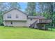 Backyard view showcasing a spacious green lawn and a wooden deck with stairs at 2140 Deer Trl, Suwanee, GA 30024