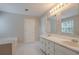 Bathroom featuring a double sink vanity, a garden tub, and ceramic tile floors at 2140 Deer Trl, Suwanee, GA 30024