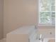 Bright bathroom with a garden tub beneath a window at 2140 Deer Trl, Suwanee, GA 30024