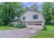 Home exterior features a two-car garage, beautiful greenery, and a well-maintained lawn at 2140 Deer Trl, Suwanee, GA 30024