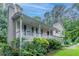 Charming home with a covered front porch, green shutters, and lush landscaping at 2140 Deer Trl, Suwanee, GA 30024