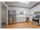 Modern kitchen featuring stainless steel appliances, white cabinets, and hardwood floors at 2140 Deer Trl, Suwanee, GA 30024
