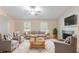 Cozy living room with a fireplace, neutral furniture, and bright windows at 2140 Deer Trl, Suwanee, GA 30024