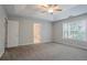 Light filled main bedroom boasts tray ceilings, ceiling fan, and ensuite bathroom at 2140 Deer Trl, Suwanee, GA 30024