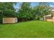 Expansive backyard featuring lush green grass, mature trees, a shed, and a screened porch, perfect for outdoor enjoyment at 3690 Basswood Rd, Snellville, GA 30039