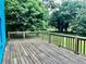 Wooden deck with wood railing attached to blue house and backyard view at 5560 Old Bill Cook Rd, College Park, GA 30349