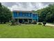 Charming two-story home with a lush green lawn and mature trees under a cloudy sky at 5560 Old Bill Cook Rd, College Park, GA 30349