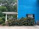 Side view of blue brick home showing a covered porch with stone support and lush plants at 5560 Old Bill Cook Rd, College Park, GA 30349