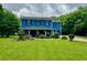 Bright blue two-story home with a well-manicured lawn and landscaping at 5560 Old Bill Cook Rd, College Park, GA 30349