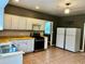 Traditional kitchen with stainless steel appliances and warm tile flooring at 5560 Old Bill Cook Rd, College Park, GA 30349