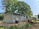 Back exterior of home featuring a small deck, neutral siding, and backyard access at 921 Marshall Fuller Rd, Dallas, GA 30157