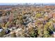 City skyline view from an aerial image of a tree-filled neighborhood in the fall at 944 Woodland Ave, Atlanta, GA 30316