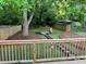 Landscaped backyard featuring a deck, fire pit, and lush greenery for outdoor enjoyment at 944 Woodland Ave, Atlanta, GA 30316
