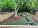 Well-maintained backyard features a stone firepit, lawn, mature shade trees, and a privacy fence at 944 Woodland Ave, Atlanta, GA 30316