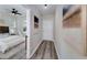 Hallway with hardwood floors leads to a bedroom with white bedding and natural decor at 944 Woodland Ave, Atlanta, GA 30316