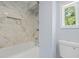 Bright bathroom features marble-look tile, a new bathtub, and a built-in wall niche at 2158 Huckleberry Ln, Lithia Springs, GA 30122