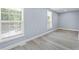Bedroom with two windows, modern vinyl plank flooring, and baseboard trim at 2158 Huckleberry Ln, Lithia Springs, GA 30122