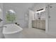 Elegant bathroom features a soaking tub, dual vanities, white tile floors, and shower at 305 River Glen Dr, Roswell, GA 30075