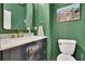 Stylish powder room with green walls, elegant vanity, marble countertop, and gold fixtures at 305 River Glen Dr, Roswell, GA 30075