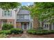 Charming two-story townhome with a well-manicured front yard and brick accents, offers inviting curb appeal at 305 River Glen Dr, Roswell, GA 30075