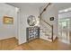 Bright foyer features hardwood floors, a staircase, decorative table, and an open view into living area at 305 River Glen Dr, Roswell, GA 30075
