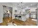 Modern kitchen featuring an island with seating, stainless steel appliances, and seamless flow from entry area at 305 River Glen Dr, Roswell, GA 30075