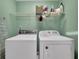 This laundry room features a washer, dryer, shelving, and ironing board ready to use at 305 River Glen Dr, Roswell, GA 30075
