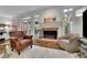 Cozy living room features a brick fireplace, hardwood floors, and natural light from multiple windows at 305 River Glen Dr, Roswell, GA 30075