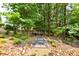 Backyard view of the outdoor fire pit area surrounded by nature at 3453 Drayton Ne Dr, Roswell, GA 30075