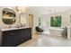 Bright bathroom featuring a soaking tub, double vanity, modern fixtures, and plenty of light at 3453 Drayton Ne Dr, Roswell, GA 30075