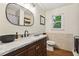 Modern bathroom with a wood vanity, granite countertop and an oval mirror at 3453 Drayton Ne Dr, Roswell, GA 30075