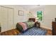 Cozy bedroom with hardwood floors, wainscotting and a window overlooking the green trees at 3453 Drayton Ne Dr, Roswell, GA 30075