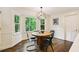 Bright breakfast nook with a round wooden table, modern light fixture and a green view at 3453 Drayton Ne Dr, Roswell, GA 30075