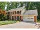 Charming two-story brick home featuring a two-car garage and a beautifully landscaped front yard with vibrant flowers at 3453 Drayton Ne Dr, Roswell, GA 30075