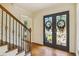 View of front entry doors with decorative metal work and staircase with hardwood floors and a wooden banister at 3453 Drayton Ne Dr, Roswell, GA 30075