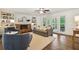 Open-concept living room featuring a brick fireplace, built-in shelves, hardwood floors, and access to the outdoors at 3453 Drayton Ne Dr, Roswell, GA 30075