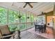 Relaxing screened porch with wood flooring, ceiling fans, and a view of the surrounding greenery at 3453 Drayton Ne Dr, Roswell, GA 30075